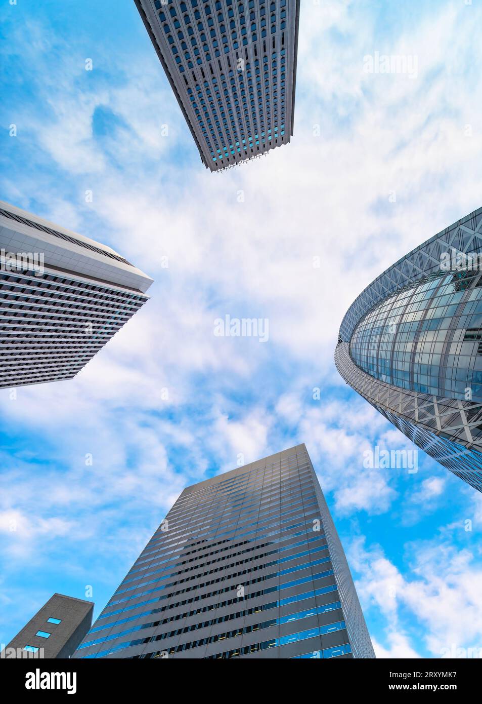 Schwindelerregender Blick auf die Wolkenkratzer unter blauem Himmel mit den Glasfassaden von Shinjukus berühmten Gebäuden wie der kokonförmigen HAL School Stockfoto