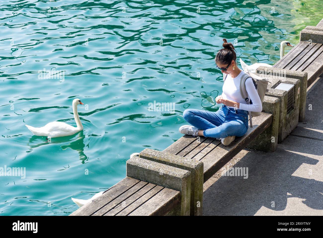 Junge Frau sitzt am Kai, Quaianlagen, Stadt Zürich, Zürich, Schweiz Stockfoto
