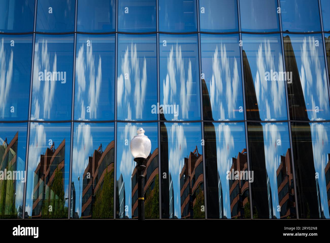 Reflexionen von Wolken und Gebäuden an der Glasfassade eines Bürogebäudes in der Innenstadt von Washington DC, USA Stockfoto
