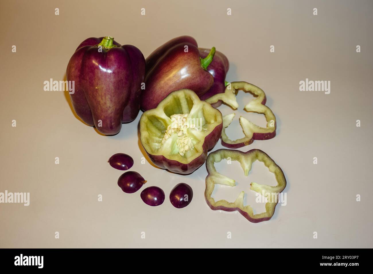 Tauchen Sie ein in eine Welt der kulinarischen Kunst durch Raju C Reddys Objektiv mit dem fesselnden Stillleben Foto von geschnittenen Purple Bell Peppers. Stockfoto
