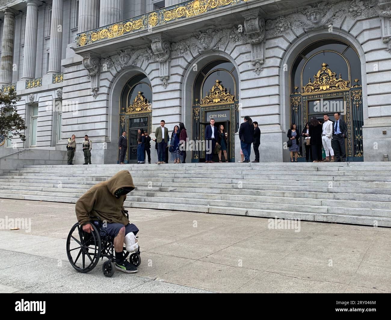 26. August 2023, San Francisco, Kalifornien, USA: Ein Obdachloser im Rollstuhl fährt am Samstag, den 26. August 2023, an der San Francisco City Hall in San Francisco, Kalifornien vorbei. Die beworbene â€˜Doom Loop Tourâ€™ war eine No-Show und sollte im Rathaus beginnen und verschiedene heruntergekommene Bereiche der Innenstadt von San Francisco abdecken. (Bild: © David G. McIntyre/ZUMA Press Wire) NUR REDAKTIONELLE VERWENDUNG! Nicht für kommerzielle ZWECKE! Stockfoto