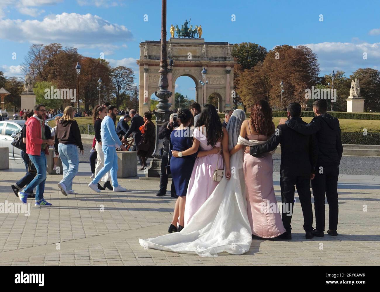 Die Hochzeitsgruppe der Immigranten posiert für ein Foto vor dem Arc de Triomphe in Paris, Frankreich Stockfoto