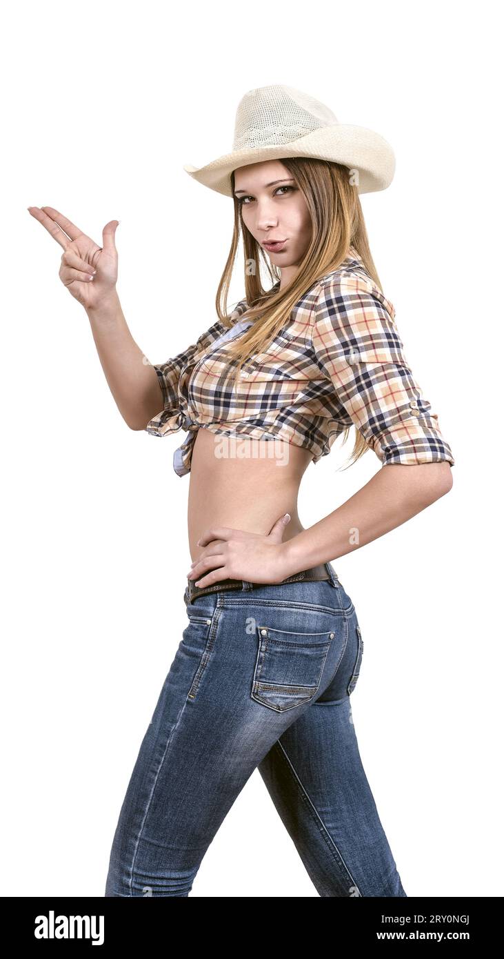 Das junge Mädchen in einem Cowboy mit Cowboyhut, Jeans und kariertem Hemd ahmt das Abfeuern einer Waffe nach. Isoliert auf weiß. Stockfoto