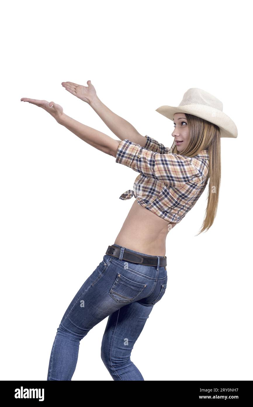 Das junge Mädchen in einem Cowboy mit Cowboyhut, Jeans und kariertem Hemd versucht etwas zu fangen. Isoliert auf weiß. Stockfoto