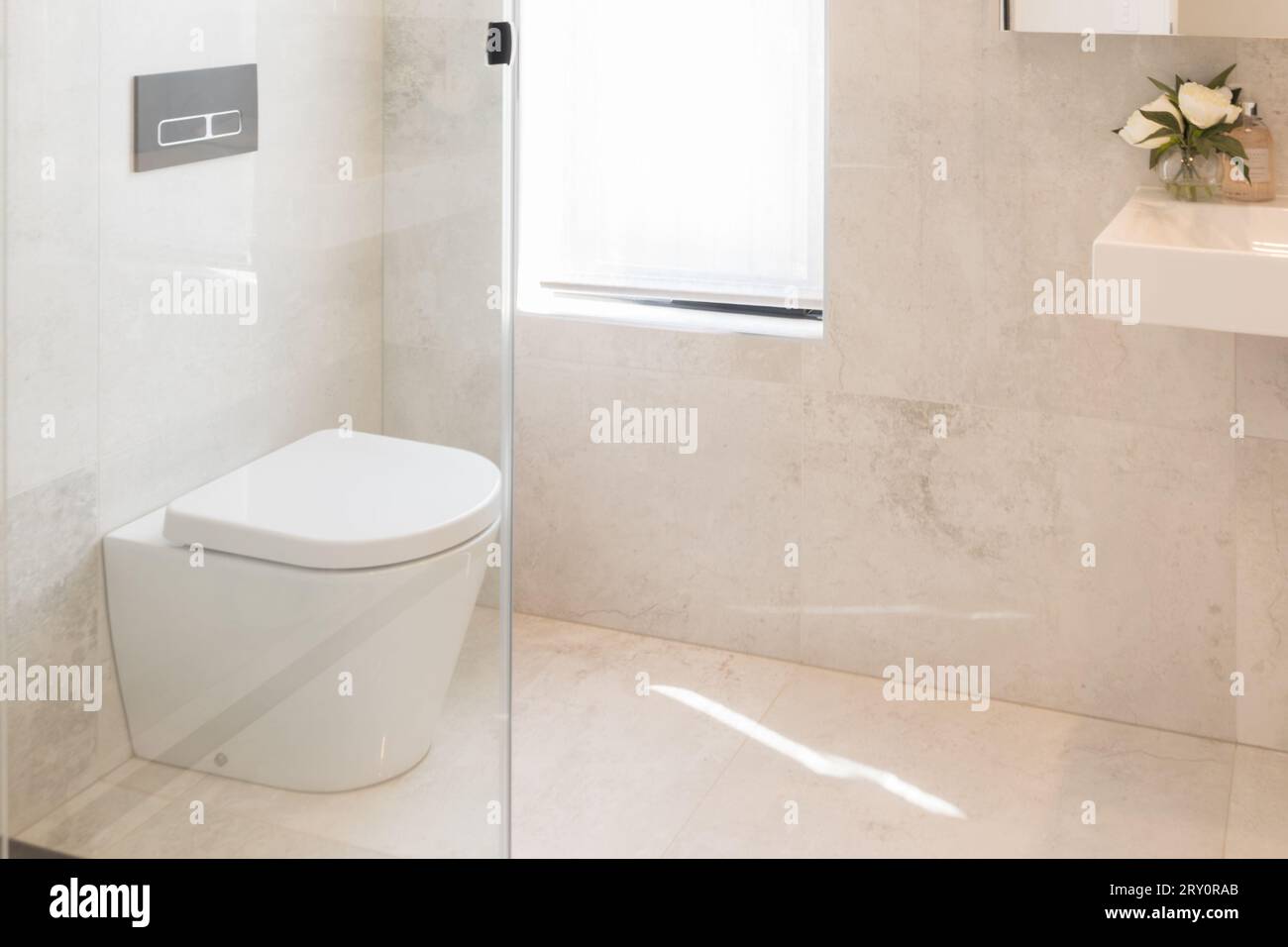 Moderne, weiße, einfache, saubere Toilette. Bad mit Duschfliesen, Wand- und Bodenfliesen Stockfoto