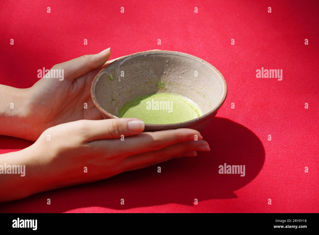 Die Hand der jungen Frau hält traditionelle japanische Grüntee-Schüssel (Macha). Stockfoto