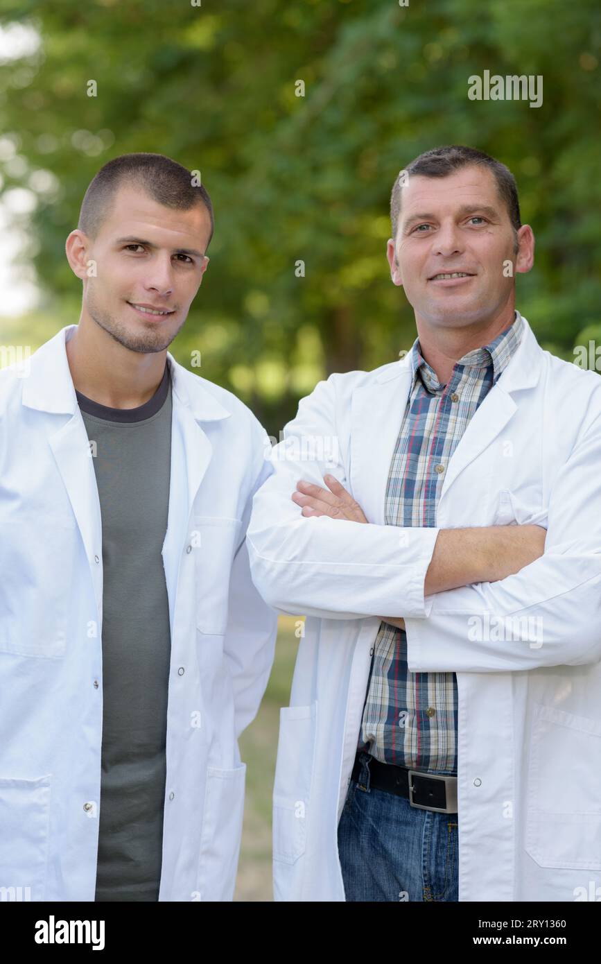 Zwei Arbeiter in Labormänteln draußen Stockfoto