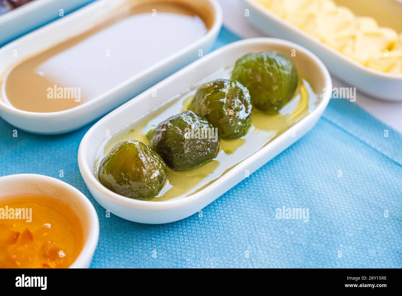 Ganze grüne Feigenmarmelade in einer weißen Porzellanschale auf dem Frühstückstisch Stockfoto