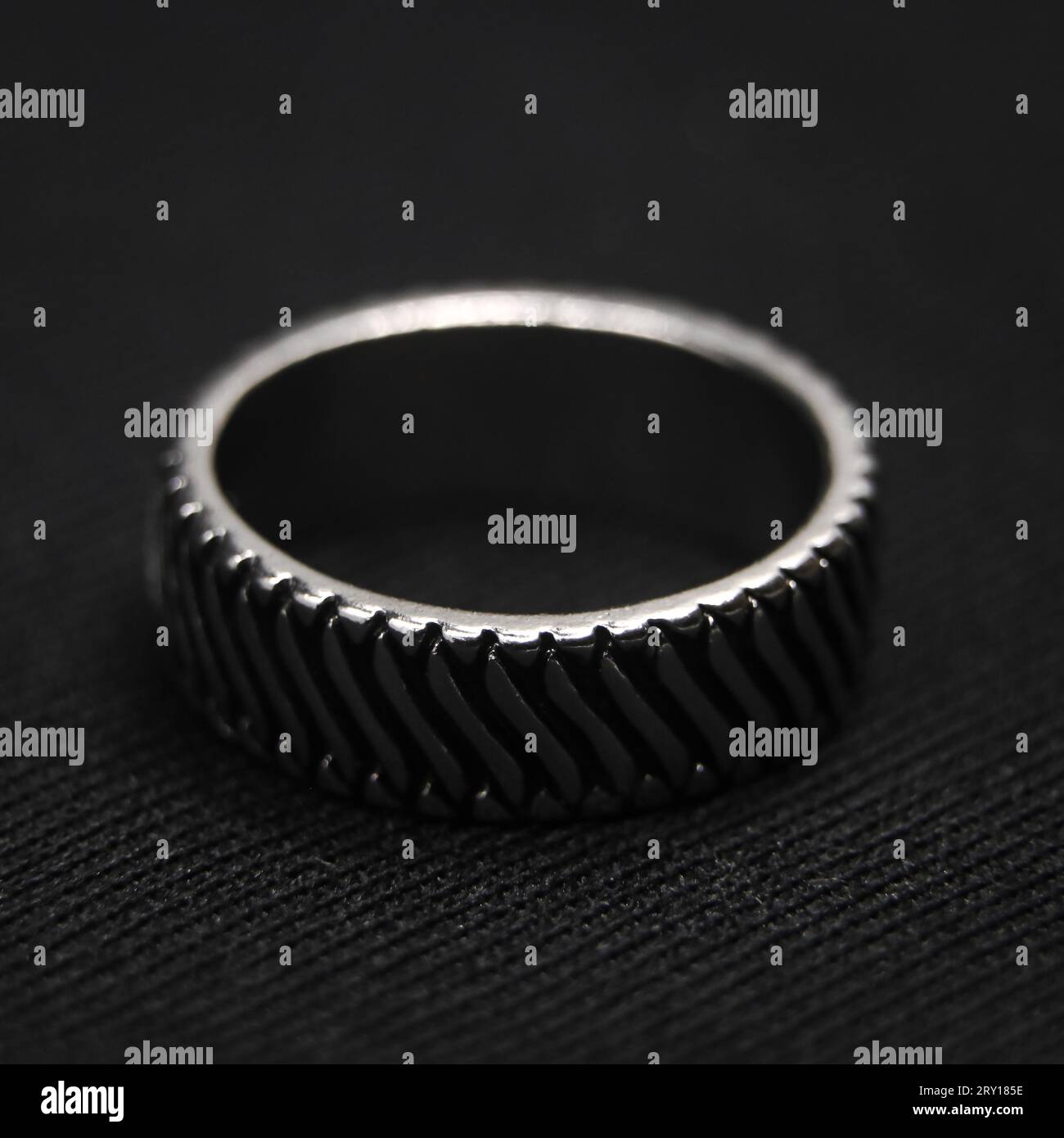 Nahaufnahme eines kreisförmigen Platinrings mit einem ordentlich geschliffenen Design, isoliert auf schwarzem Hintergrund Stockfoto