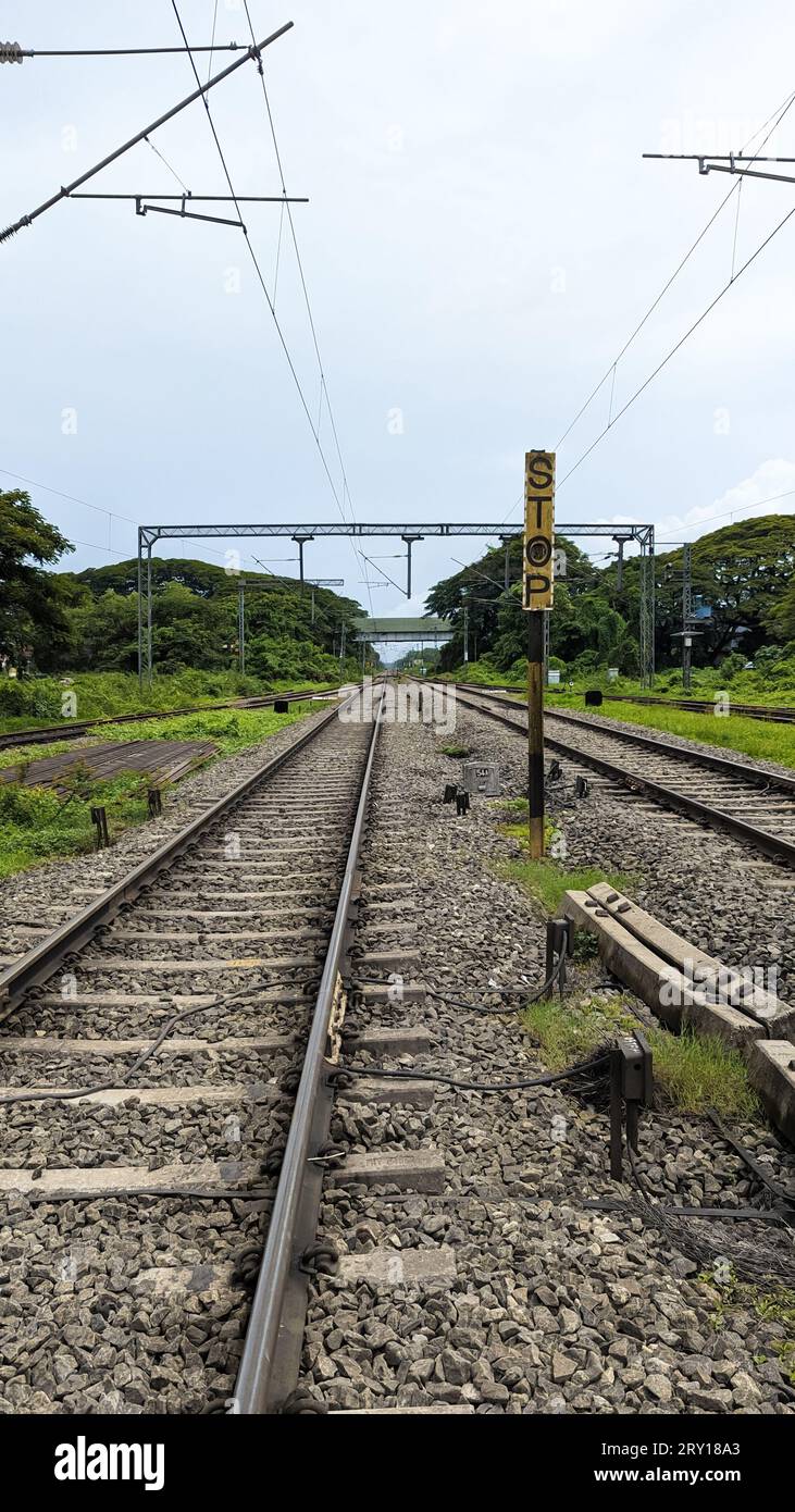 Eisenbahngleise in der Landschaft, umgeben von Grün an einem Sommertag Stockfoto