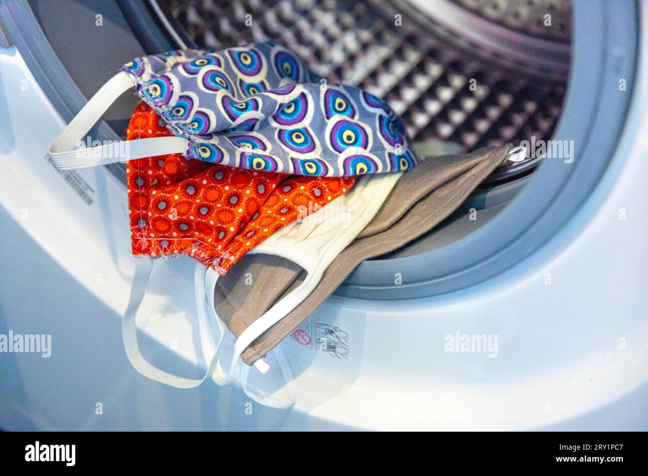 Waschen der Stoffmaske in der Waschmaschine Stockfoto Waschen der Stoffmaske in der Waschmaschine Stockfoto
