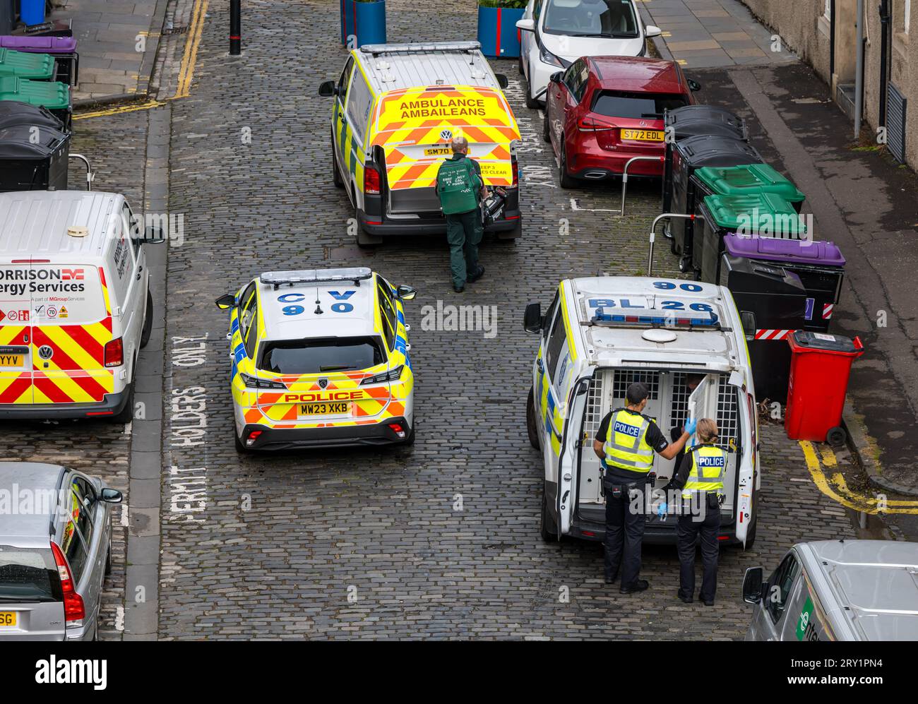 Polizeibeamte verhaften einen Mann und sperren ihn in einem Polizeiwagen in Leith, Edinburgh, Schottland, Großbritannien ein Stockfoto
