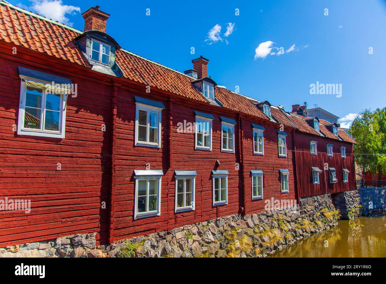 Europa, Skandinavien, Schweden... Västmanland. Västerås. Rote Holzhäuser am Ufer des Flusses Svartån Stockfoto