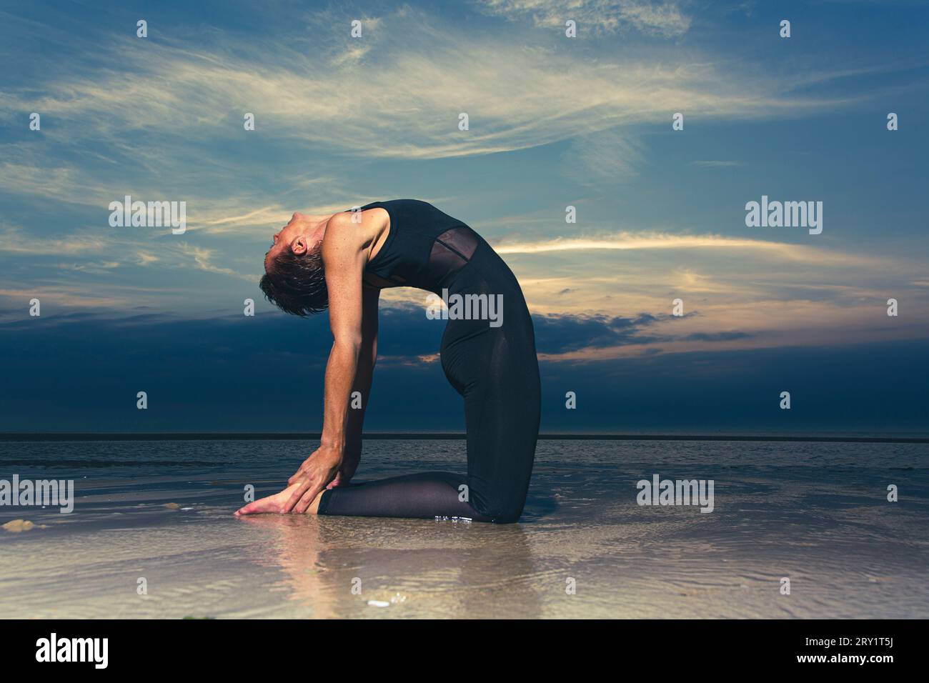 Sportliche Frau, Die Yoga Am Meer Macht Stockfoto