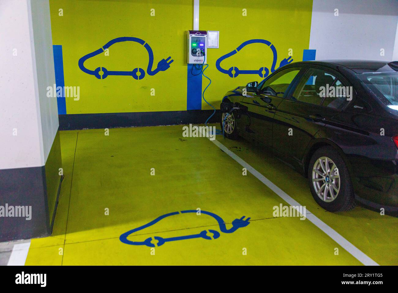 Elektroauto wird in einer Tiefgarage aufgeladen Stockfoto