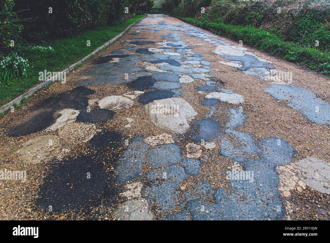 . Englische Straße mit Schlaglöchern und Bitumenreparatur Stockfoto