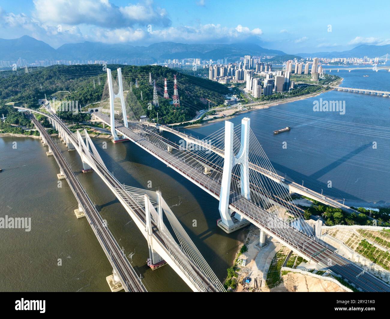 FUZHOU, 28. September 2023 (Xinhua) -- dieses Luftbild vom 26. September 2023 zeigt die Wulong River Bridge (C) entlang der Fuzhou-Xiamen-Zhangzhou Hochgeschwindigkeitsbahn in der südöstlichen chinesischen Provinz Fujian. Chinas schnellste Hochgeschwindigkeitsstrecke für den Seeverkehr nahm am Donnerstag den Betrieb auf, wobei die Züge mit einer Höchstgeschwindigkeit von 350 km/h entlang der Westküste der Straße von Taiwan verkehrten. Ein Fuxing-Hochgeschwindigkeitszug G9801 fuhr um 9:15 Uhr von Fuzhou, der Hauptstadt der südöstlichen chinesischen Provinz Fujian, ab und feierte die Eröffnung der 277 km langen Hochgeschwindigkeitsbahn Fuzhou-Xiamen-Zhangzhou. Das ist das erste Mal in China Stockfoto