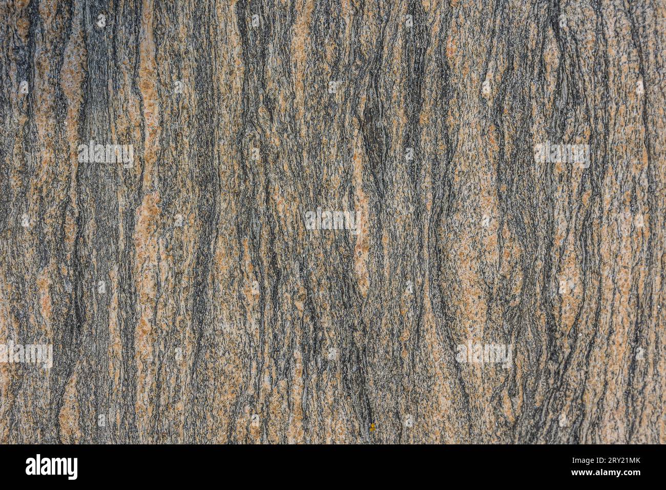 Musterhintergrund aus Granitstein. Vertikale Linien von einer braunen Steinoberfläche. Strukturen werden durch dunkle Farben sichtbar. Natürliches Material Stockfoto