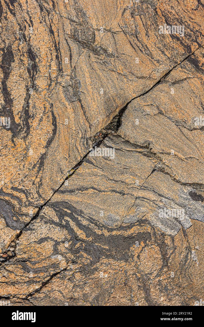 Grobes Wellenmuster in braunem Granitstein. Hintergrundmuster des Natursteins. Diagonaler Strukturbruch in der Fläche. Isolierter grauer und dunkler Bereich Stockfoto