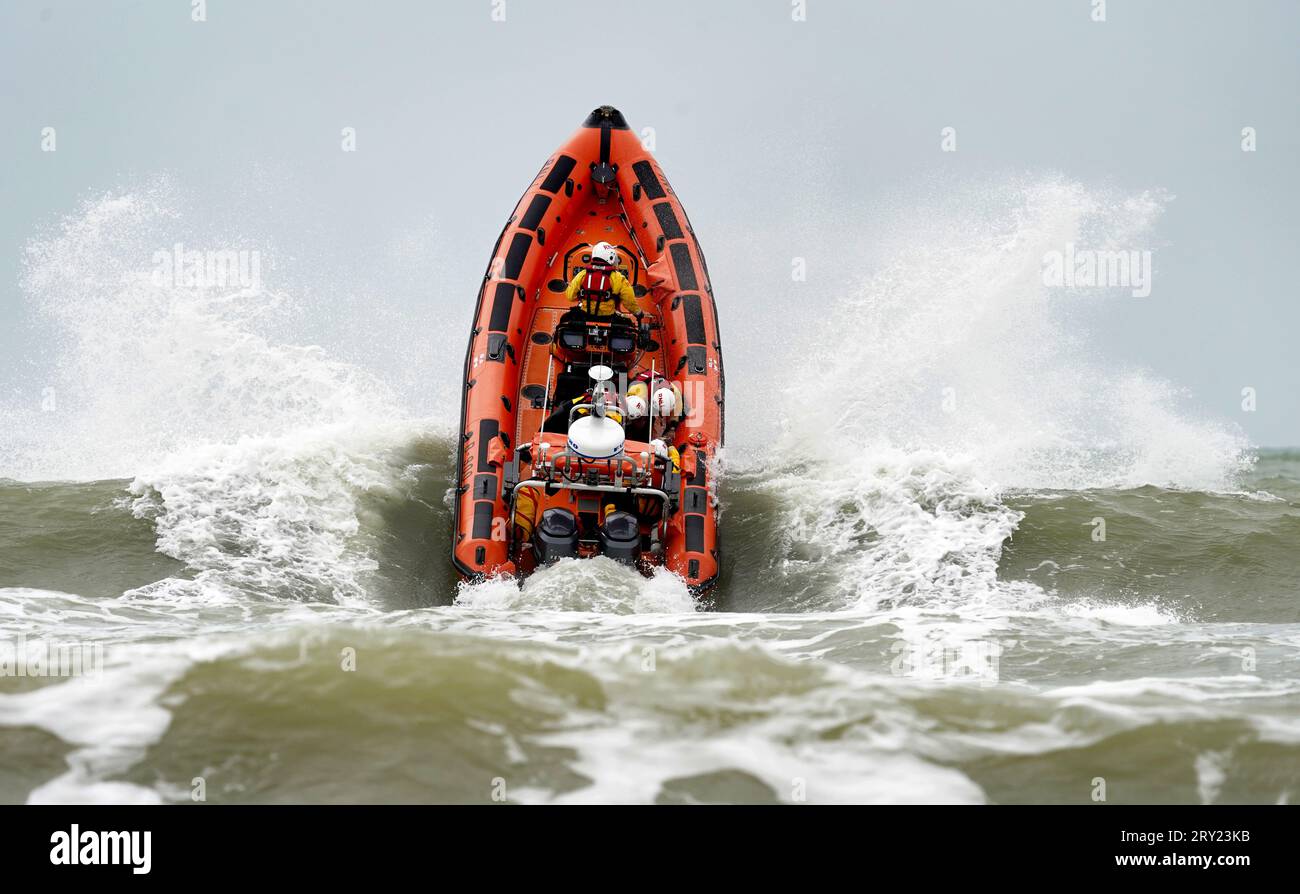 Ein RNLI-Rettungsboot stürzt durch Wellen während einer Übung mit mehreren Behörden ab, um die Notfallreaktion in Camber Sands, East Sussex, zu testen. Die vom South East Coast Ambulance Service (SECAmb) organisierte Multi-Agency-Übung umfasst auch Sussex Police, East Sussex Fire and Rescue Service, Rother District Council, HM Coastguard und RNLI Lifeguards. Bilddatum: Donnerstag, 28. September 2023. Stockfoto