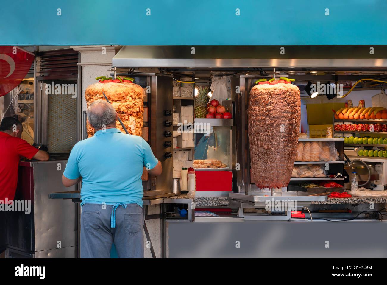 Döner-Koch, der Hühnchen- und Fleischdöner in einem Döner-Laden zubereitet. Stockfoto
