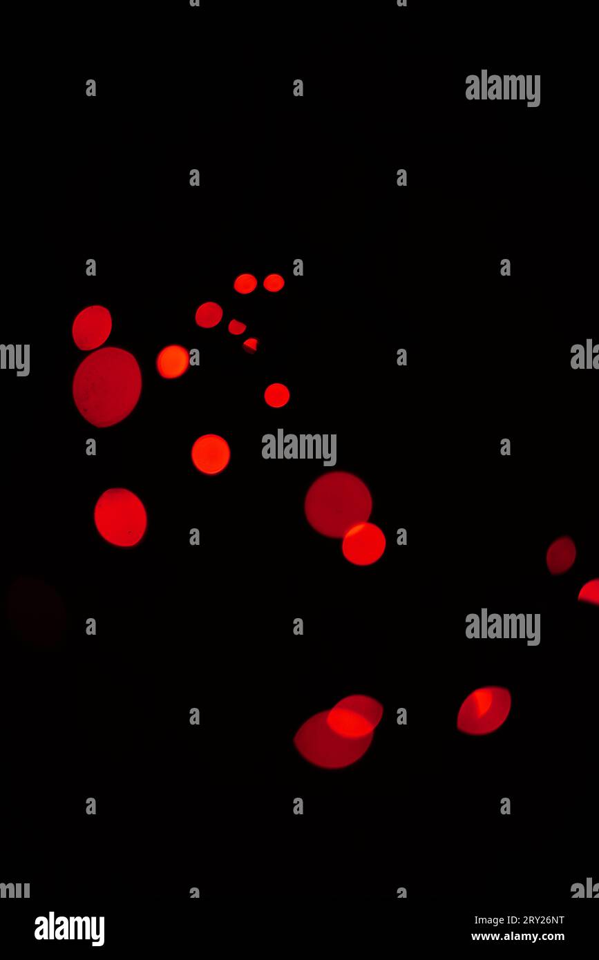 Bokeh, rote Punkte und Lichter auf schwarzem Hintergrund mit Muster, Textur und Mockup mit kosmischer Ästhetik. Nachtbeleuchtung, Glitzerpartikel und Leuchten an Stockfoto