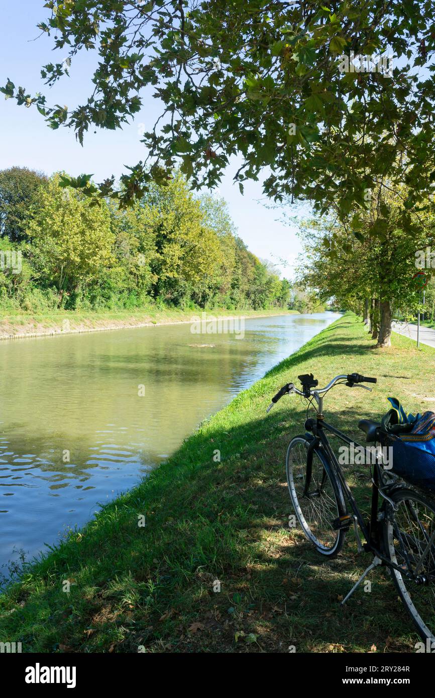 Fahrrad geparkt am von Bäumen gesäumten Flussufer während eines ökologischen Ausflugs in der Provinz Riviera del Brenta von Venedig Stockfoto