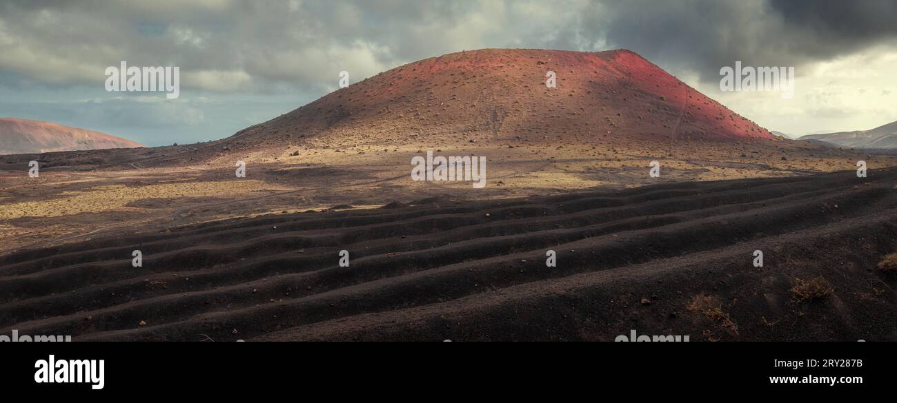 Panoramaaufnahme eines roten Vulkans in einer Wüstenlandschaft Stockfoto