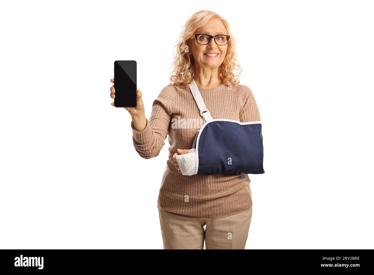 Frau mit einer Armverletzung, die eine Schlinge trägt und ein Smartphone isoliert auf weißem Hintergrund zeigt Stockfoto