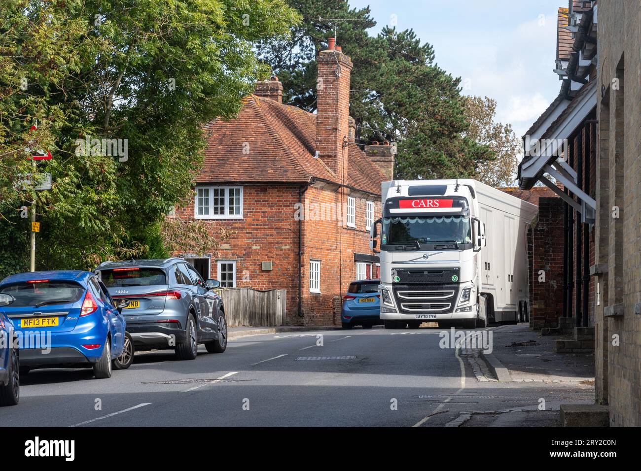 Beaulieu Village im New Forest, Hampshire, England, Vereinigtes Königreich. Ein großer Lkw, der auf der schmalen Straße an einem Auto vorbeifahren möchte Stockfoto