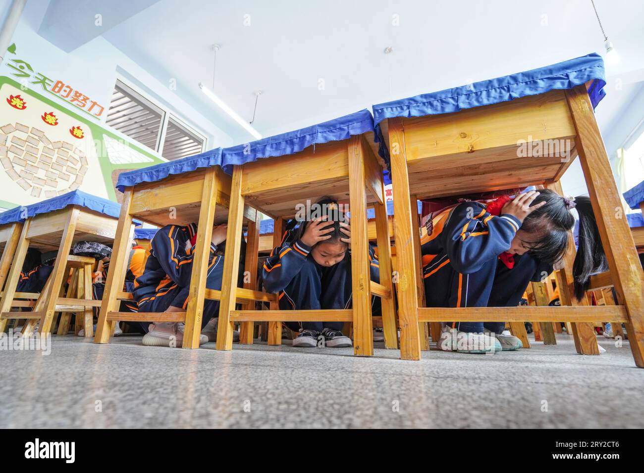 Luannan County, China - 9. Mai 2023: Grundschüler führen in einer Schule Notfallübungen zur Erdbebenprävention durch. Stockfoto