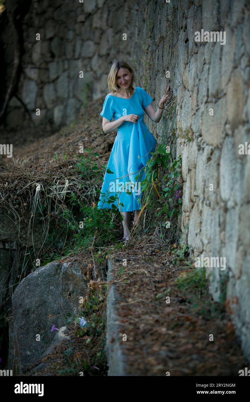 Eine Frau in blauem luftigem Kleid in mittelalterlichen Ruinen. Stockfoto