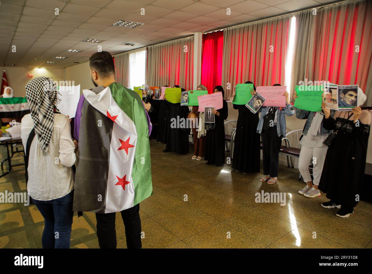 28. September 2023: Gaziantep, Turkiye. 28. September 2023. Eine Reihe von Mitgliedern syrischer Gemeindeorganisationen treffen sich in der Bulbulzadeh Hall in der Innenstadt von Gaziantep, um sich mit den anhaltenden Protesten gegen die Regierung in der syrischen Südweststadt Suweida zu solidarisieren. Während der Veranstaltung in der südtürkischen Stadt Gaziantep hissten einige Teilnehmer die syrische Oppositionsflagge sowie Banner gegen die nationale Koalition der syrischen Revolutions- und Oppositionskräfte. Der Veranstalter, Ensaf Naser, argumentierte, dass die syrische nationale Koalition die Syrer nicht repräsentiere. Während ihrer Rede Stockfoto