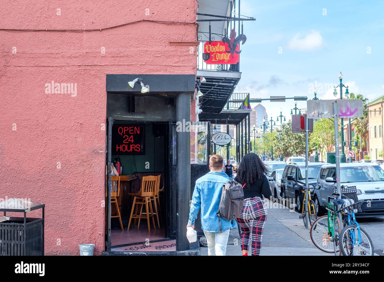 NEW ORLEANS, LA, USA - 26. MÄRZ 2023: Fußgänger passieren die offene Tür der Voodoo Lounge auf der Rampart Street im French Quarter Stockfoto