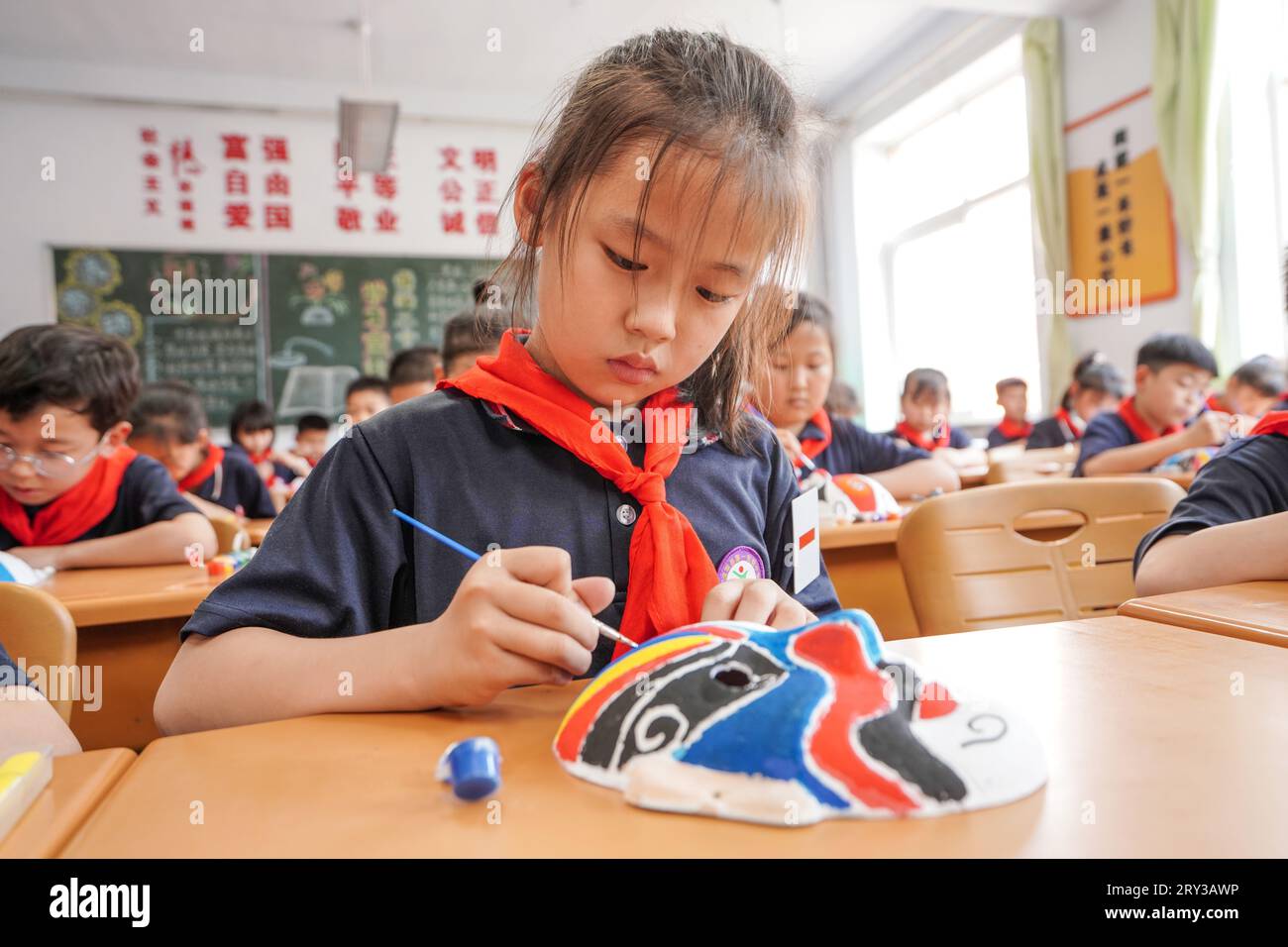 Luannan County, China - 16. Mai 2023: Grundschüler fügen Farben zu Peking Opera Gesichtsschminke in der Klasse, Nordchina hinzu Stockfoto