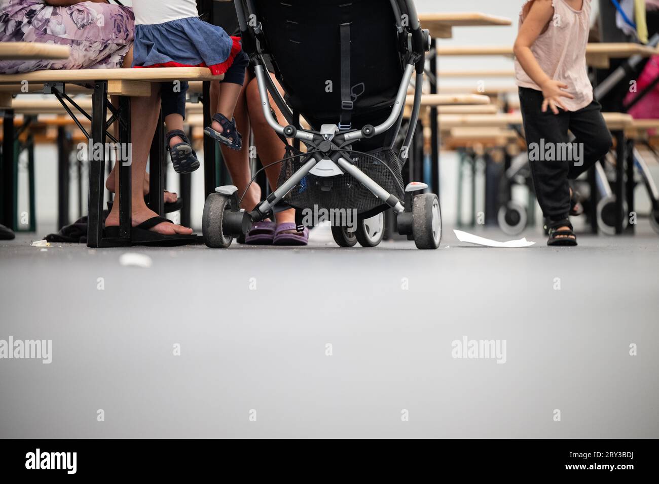 Berlin, Deutschland. September 2023 28. Bewohner mit Kindern sitzen im Speiseraum des Flüchtlingsnotfalles am ehemaligen Flughafen Tegel. Quelle: Sebastian Gollnow/dpa/Alamy Live News Stockfoto