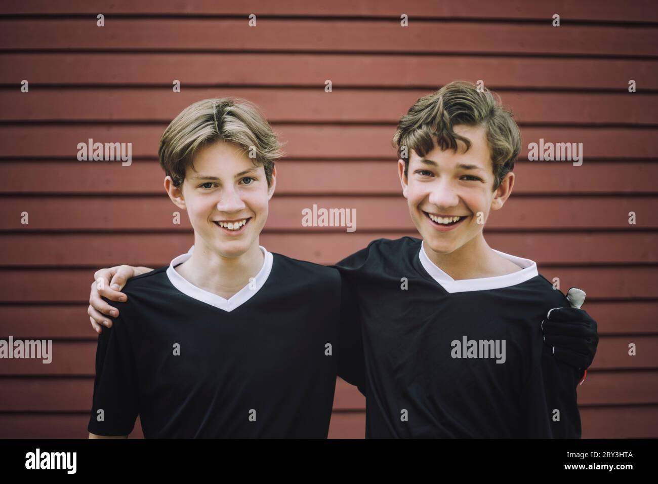Porträt glücklicher Teenager, die mit Armen an der Wand stehen Stockfoto