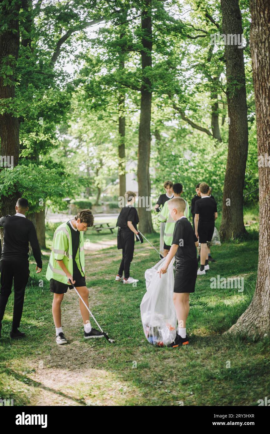 Die ganze Länge von männlichen Freunden sammelt Plastik in Müllsack Stockfoto