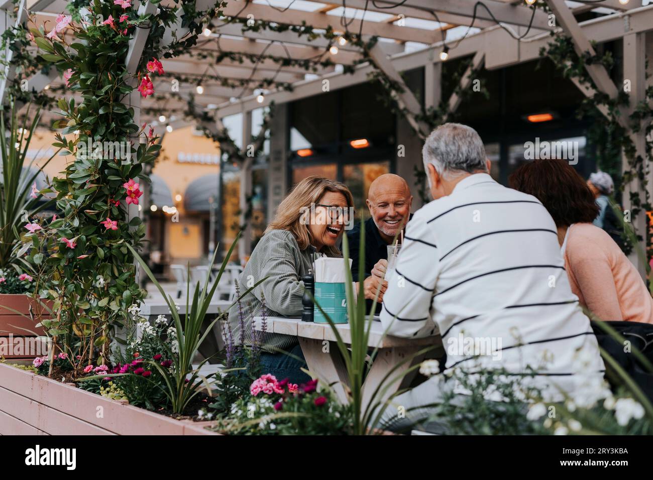 Glückliche ältere Freundinnen und Freundinnen, die Spaß im Restaurant haben Stockfoto