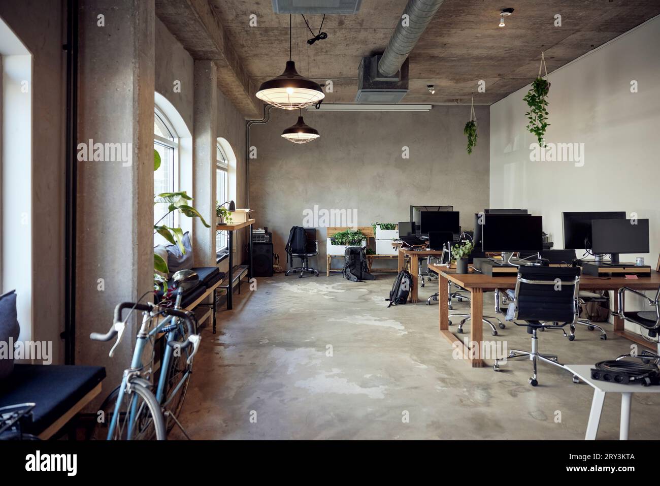 Computer auf Schreibtischen mit Stühlen im Büro Stockfoto