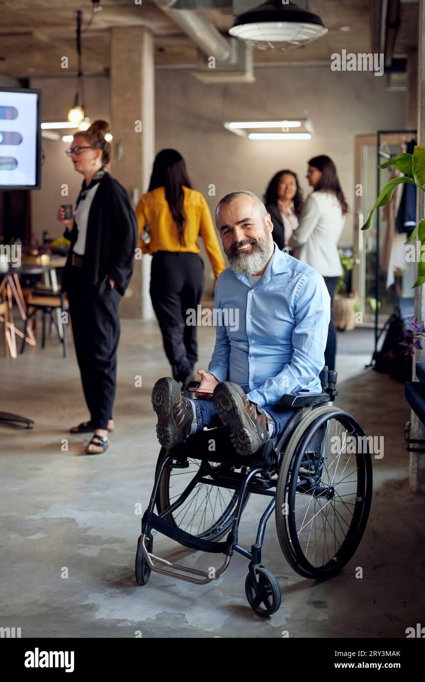 Porträt eines glücklichen Geschäftsmannes mit Behinderung im Rollstuhl im Büro Stockfoto
