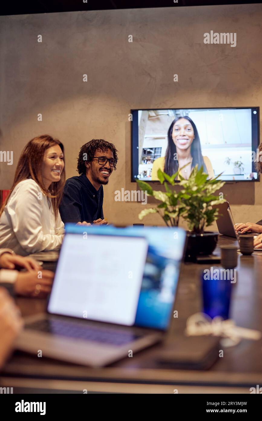 Lächelnde Geschäftskollegen während eines virtuellen Meetings im Kreativbüro Stockfoto