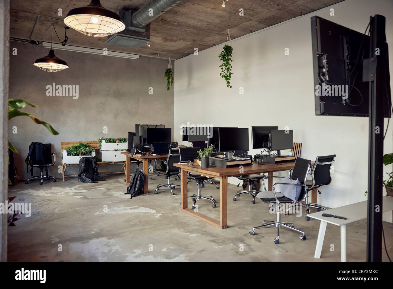 Computer auf Schreibtischen mit Stühlen im Büro Stockfoto