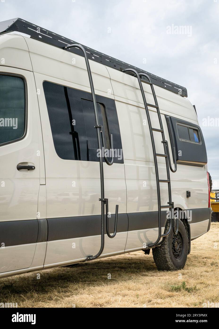 Wohnmobil mit Dachleiter und Surfbrett- oder Paddleboard-Racks. Stockfoto