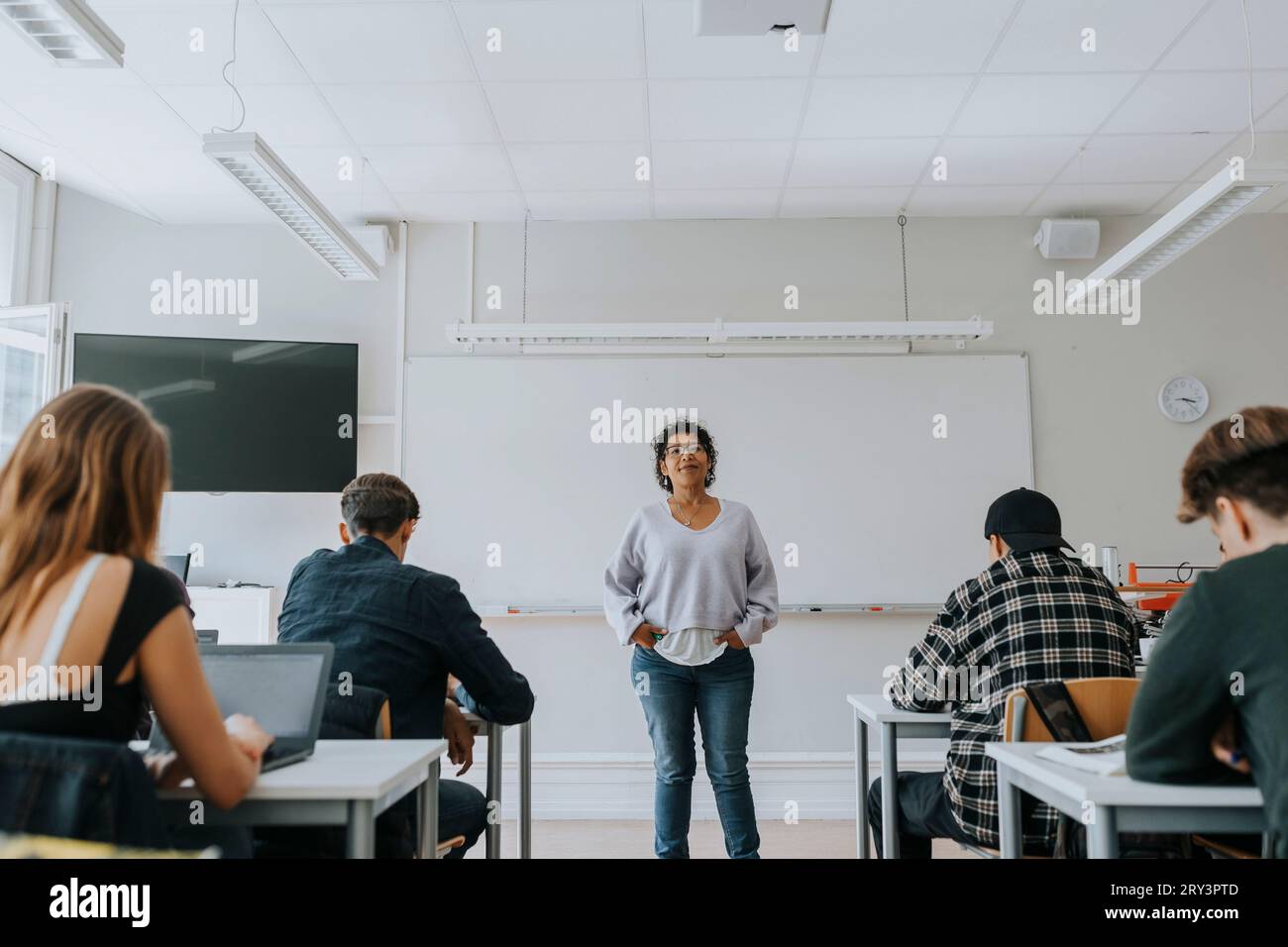Porträt einer Lehrerin mit Schülern gegen Whiteboard im Klassenzimmer Stockfoto