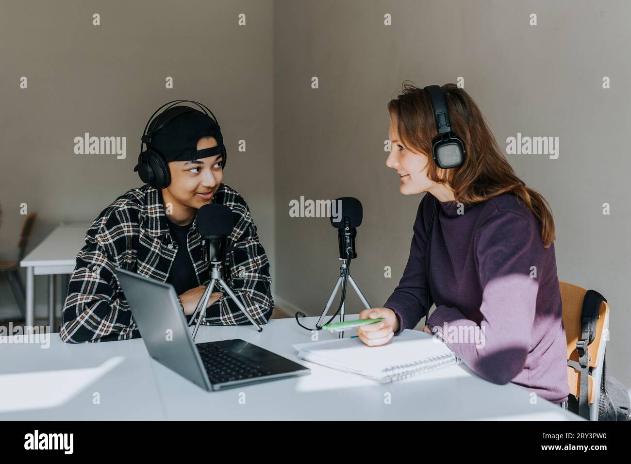 Junge Schülerinnen und Schüler, die während eines Podcasts im Klassenzimmer sprechen Stockfoto