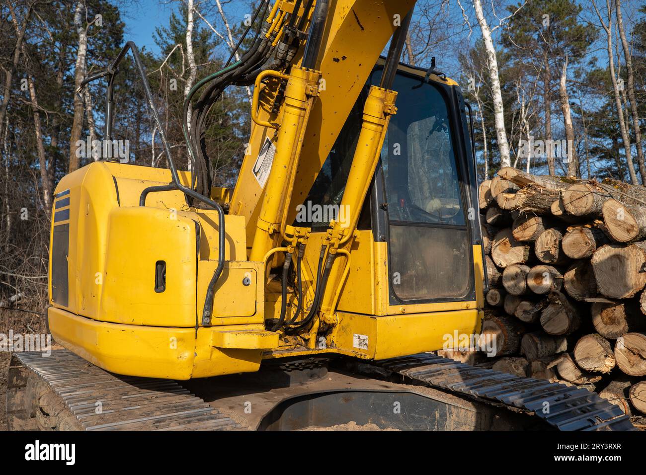 Eine gut verschlissene, gelbe Kabine, Motorraum und Basis des Arms, alle über den Stahlketten. Stockfoto