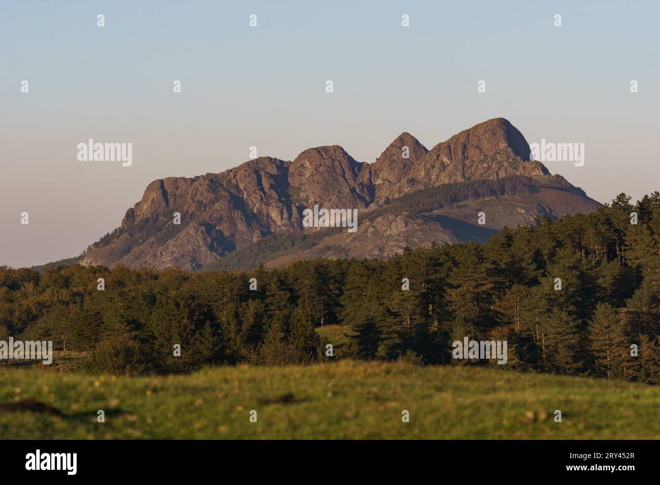 Baskische Landschaft zur goldenen Stunde bei Sonnenuntergang mit Wald und Berggipfel Erroilbide Felsformation, Aiako Harria, Gipuzkoa, Baskenland, Spanien Stockfoto