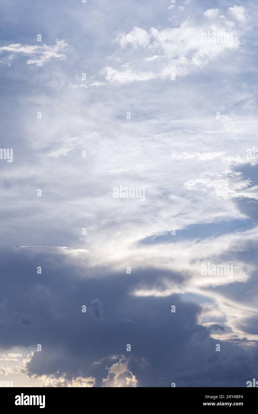 Landschaft des blauen Himmels mit Wolken und Sonnenstrahlen, die einige Bereiche zwischen Grau und Dunkelblau beleuchten. Hintergrund der Vektorhimmel-Textur Stockfoto