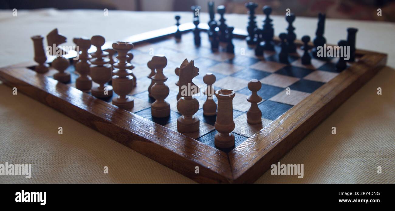 Holz gedreht Schachbrett gegen das Licht gesehen. Hintergrund des Wohnzimmers im Cottage Stockfoto